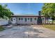 Front exterior showcasing a well-kept lawn, a concrete driveway, and a charming, gray home at 12595 95Th N St, Largo, FL 33773