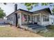 Charming home exterior featuring a quaint front porch, black chimney, and an American flag at 12595 95Th N St, Largo, FL 33773