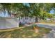 Exterior view of gray home featuring a well-maintained lawn, concrete driveway, and white picket fence at 12595 95Th N St, Largo, FL 33773