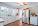 Well-lit kitchen featuring a stainless steel refrigerator, white cabinets, and marble countertops at 12595 95Th N St, Largo, FL 33773