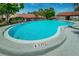 Wide shot of the outdoor pool, with stairs leading into the clear blue water at 1288 Powderpuff Dr # 1202, Dunedin, FL 34698