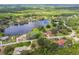 Beautiful aerial view of lakefront homes, lush trees, and a serene lake perfect for peaceful living at 13003 Titleist Dr, Hudson, FL 34669