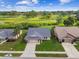 Aerial view of homes showing well-manicured lawns and close proximity to a golf course and pond at 13003 Titleist Dr, Hudson, FL 34669