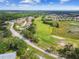 An aerial view showcases the community golf course, manicured lawns, and surrounding wooded areas at 13003 Titleist Dr, Hudson, FL 34669