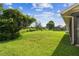 Expansive backyard featuring lush lawn and mature trees offering a serene outdoor space at 13003 Titleist Dr, Hudson, FL 34669