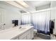 Bathroom featuring a large mirror, vanity with storage, and a shower with a blue ombre curtain at 13003 Titleist Dr, Hudson, FL 34669