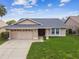 Charming single-story home featuring a two-car garage and well-maintained lawn at 13003 Titleist Dr, Hudson, FL 34669