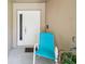 Inviting entryway with a white front door and a comfortable outdoor chair at 13003 Titleist Dr, Hudson, FL 34669