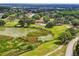 A lush golf course landscape is captured from above, highlighting water features, trees, and a clubhouse at 13003 Titleist Dr, Hudson, FL 34669