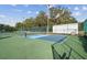 Community pickleball court with blue lines, nets, green surface and access to equipment storage at 13003 Titleist Dr, Hudson, FL 34669