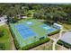 Aerial view of tennis and pickleball courts, shaded by mature trees at 13003 Titleist Dr, Hudson, FL 34669