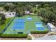 Aerial view of tennis and pickleball courts surrounded by lush greenery at 13003 Titleist Dr, Hudson, FL 34669