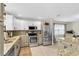 Bright kitchen with stainless steel appliances, granite countertops, white cabinets, and modern fixtures at 1313 Markley Dr, Largo, FL 33770
