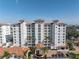 Exterior view of a high-rise waterfront condominium with red tile roofs, palm trees, and a circular driveway at 1325 Snell Isle Ne Blvd # 505, St Petersburg, FL 33704