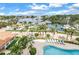 Aerial view showcases a beautiful pool area with lounge chairs and palm trees overlooking the marina at 1325 Snell Isle Ne Blvd # 505, St Petersburg, FL 33704