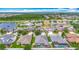 An aerial perspective captures a neighborhood with lush green spaces and pond views surrounding multiple residences at 13608 Artesa Bell Dr, Riverview, FL 33579