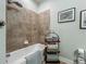 Well-lit bathroom features tiled shower with shower head and a towel rack at 13608 Artesa Bell Dr, Riverview, FL 33579