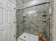Accessible shower features a rainfall shower head, grab bars and sleek glass doors at 13608 Artesa Bell Dr, Riverview, FL 33579