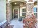 Close-up of the front door with stone detailing, a wreath, and planters at 13608 Artesa Bell Dr, Riverview, FL 33579