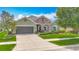 Charming one-story home featuring a stone facade, manicured lawn, and a two-car garage at 13608 Artesa Bell Dr, Riverview, FL 33579