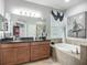 Spacious main bathroom with double vanity, soaking tub, and decorative accents at 13608 Artesa Bell Dr, Riverview, FL 33579