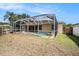 View of the screened-in pool in the backyard with mature trees and a well-maintained lawn at 14042 Marlberry Way, Odessa, FL 33556