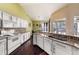 Well-lit kitchen showcasing granite countertops, white cabinetry, mosaic backsplash, and hardwood floors at 14042 Marlberry Way, Odessa, FL 33556