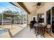 Inviting covered patio area with a dining set, fan, and a view of the screened-in pool at 14042 Marlberry Way, Odessa, FL 33556