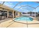Relaxing screened-in pool area with a sparkling pool, a patio dining set, and clear blue skies overhead at 14042 Marlberry Way, Odessa, FL 33556