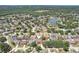 Aerial view of a residential neighborhood featuring single-Gathering homes, tree-lined streets, and a nearby pond at 1421 Buckner Rd, Valrico, FL 33596
