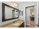 Bathroom with granite counters, a framed mirror and easy access to other rooms at 1421 Buckner Rd, Valrico, FL 33596