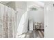 Bright bathroom with a skylight, modern flooring, and walk-in shower featuring a charming vanity and full-length mirror at 1421 Buckner Rd, Valrico, FL 33596