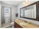 Well-lit bathroom featuring a granite countertop, wood cabinets, and a large mirror at 1421 Buckner Rd, Valrico, FL 33596