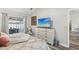 Bright primary bedroom featuring a king-sized bed, a dresser with TV and sliding glass doors to the outdoor space at 1421 Buckner Rd, Valrico, FL 33596