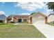 Charming single-story home with brick accents, a blue front door, and a well-maintained lawn under a bright, partly cloudy sky at 1421 Buckner Rd, Valrico, FL 33596