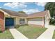 Close-up of a well-maintained home showcasing a blue front door, brick accents, and manicured landscaping at 1421 Buckner Rd, Valrico, FL 33596