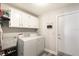 Laundry room featuring white cabinets, modern washer and dryer, and convenient storage shelving at 1421 Buckner Rd, Valrico, FL 33596