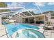 Inviting pool area with screened enclosure, spa and covered patio at 1421 Buckner Rd, Valrico, FL 33596