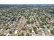Expansive aerial view of a residential neighborhood with mature trees and distant water views at 1450 Seabreeze St, Clearwater, FL 33756