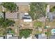 Detailed aerial view of a backyard with solar panels, a wooden deck, and mature shade trees at 1450 Seabreeze St, Clearwater, FL 33756