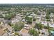 A wide aerial view of a neighborhood shows the yellow single-story home with solar panels is in a central location at 1450 Seabreeze St, Clearwater, FL 33756