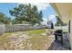 Large backyard with lawn and an outdoor dining set on a brick patio with a grill at 1450 Seabreeze St, Clearwater, FL 33756