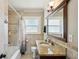 Bathroom featuring a granite countertop vanity, framed mirror, and shower-tub combo at 1450 Seabreeze St, Clearwater, FL 33756