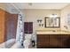 Well-lit bathroom with a shower-tub combo, granite vanity, and decorative mirror, blending functionality with style at 1450 Seabreeze St, Clearwater, FL 33756