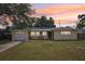Charming one-story yellow home featuring a well-maintained lawn and welcoming front porch area at 1450 Seabreeze St, Clearwater, FL 33756