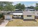 Aerial view of yellow single-story home with solar panels and charming front porch sitting area at 1450 Seabreeze St, Clearwater, FL 33756