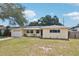 Charming yellow single-story home with solar panels, a front porch sitting area, and a well-maintained lawn at 1450 Seabreeze St, Clearwater, FL 33756