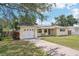 Charming single story home has a white garage door, solar panels and cozy front patio at 1450 Seabreeze St, Clearwater, FL 33756