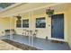 Welcoming front porch featuring hanging plants, seating, and a stylish blue front door at 1450 Seabreeze St, Clearwater, FL 33756