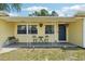 Charming front porch with a cozy seating area, hanging flower baskets, and stylish decorative accents at 1450 Seabreeze St, Clearwater, FL 33756